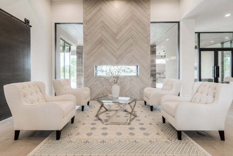 Luxury Vacant Home StagingFrisco new construction living room with tailored seating, a fireplace, and layered furnishings