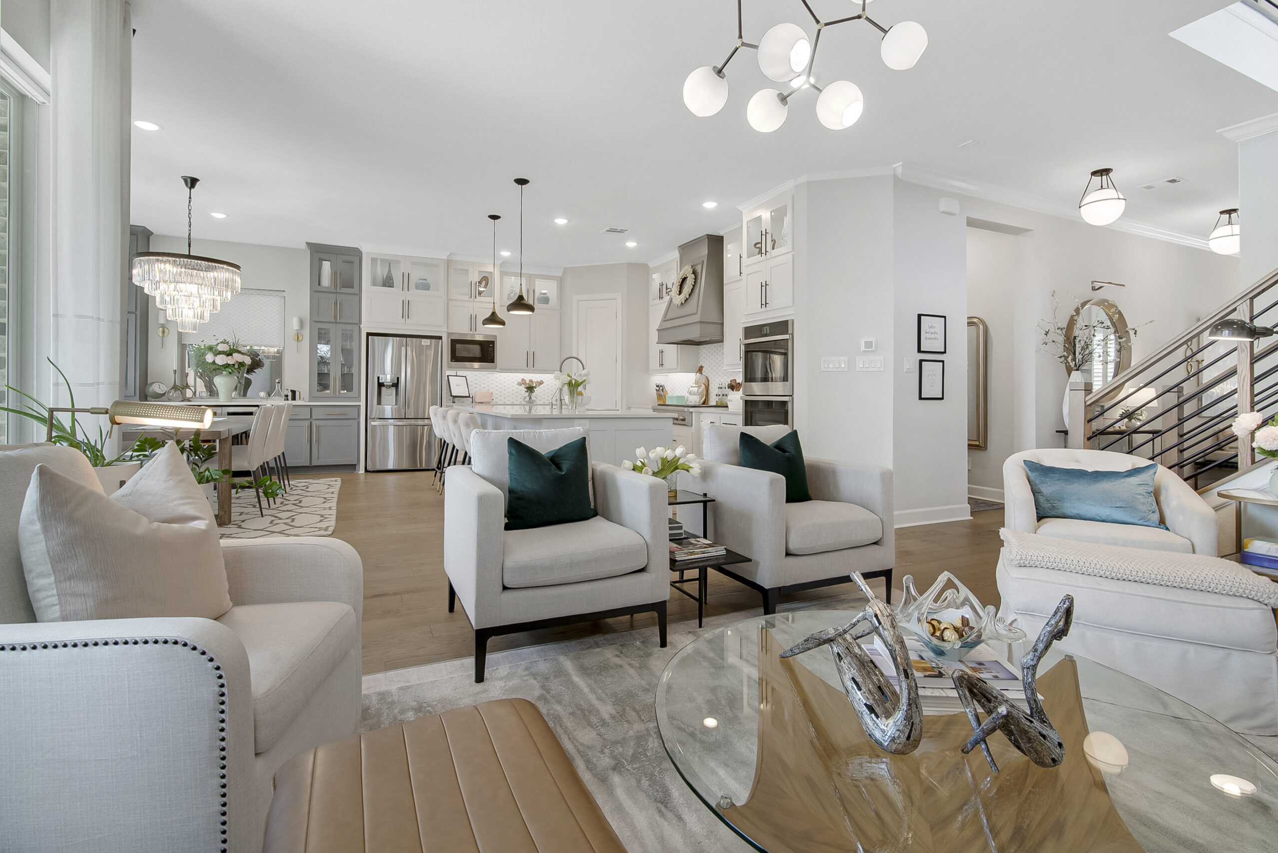 Open-concept Dallas living space with neutral furnishings and layered lighting by Design by KETI